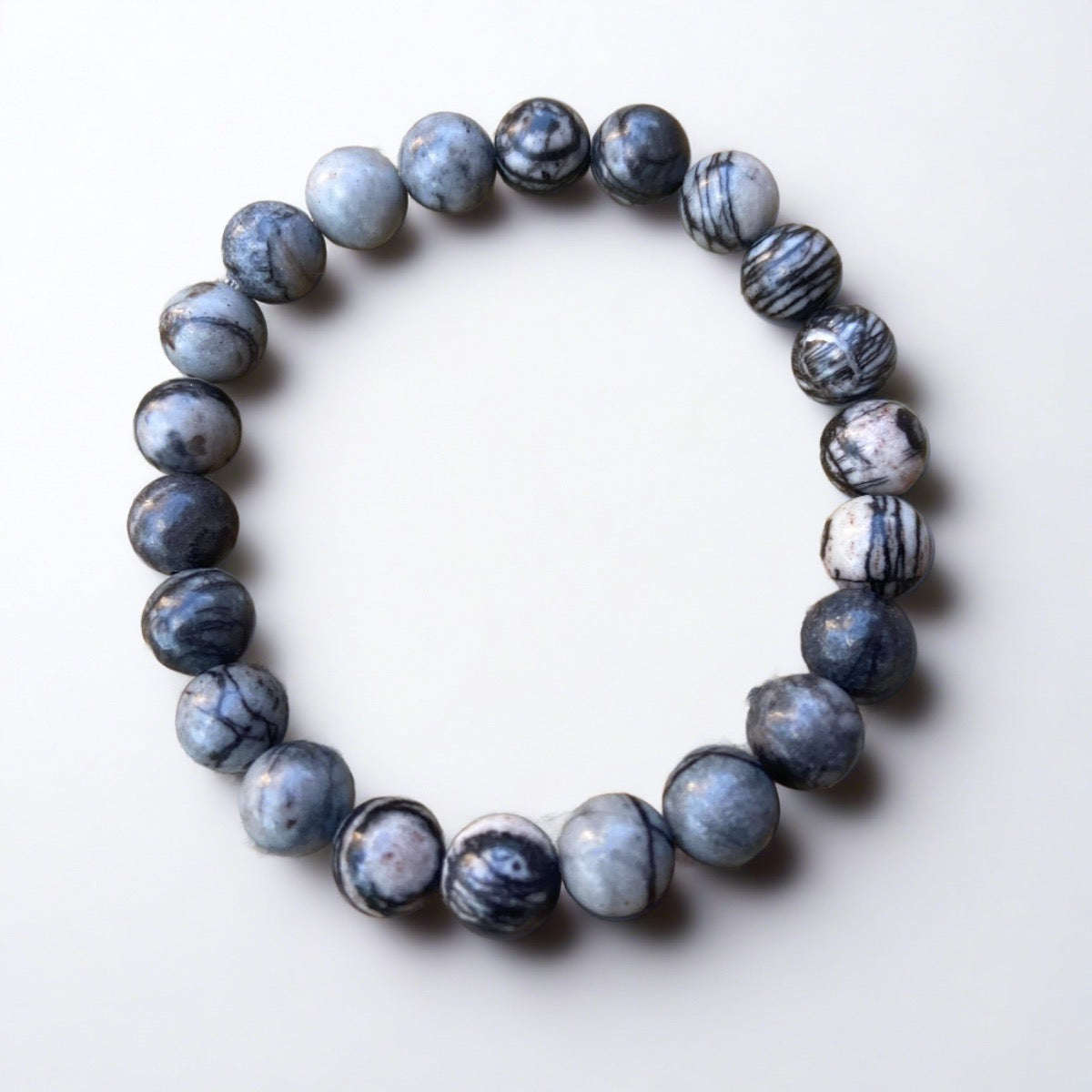 Unique Black Water Jasper Bracelet made with authentic stones on a gray background, a stunning piece of unusual mindfulness jewelry