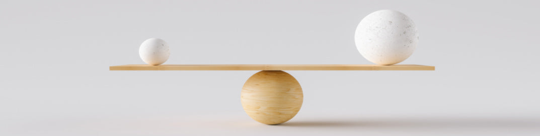 A wooden scale with two small white objects balanced on either side, representing equilibrium or balance