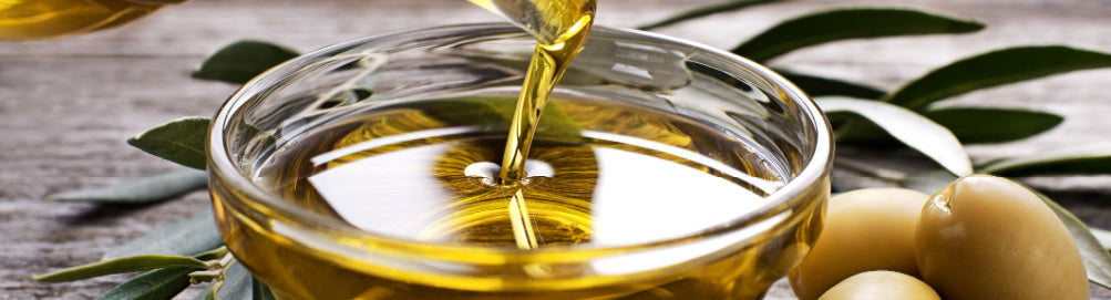 Olive oil being poured into a bowl to represent back to basic skincare ingredients