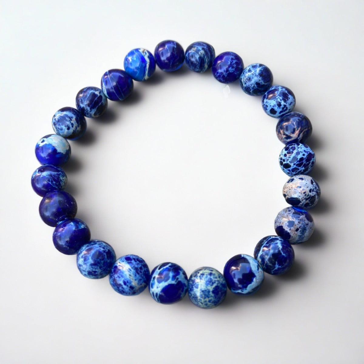 Midnight Blue Impression Jasper mala bracelet on rock background