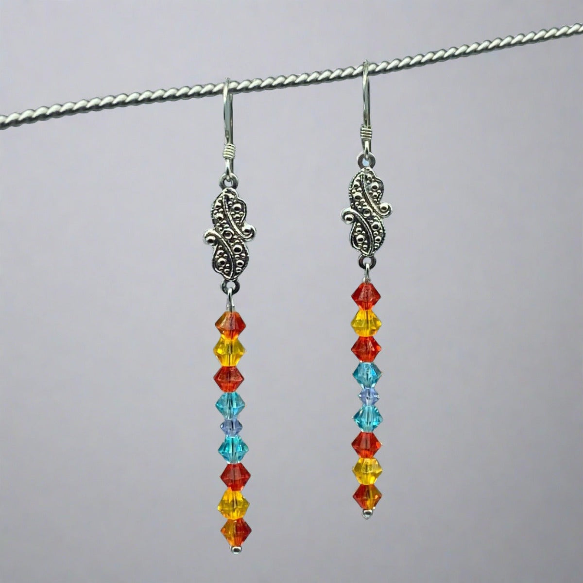Beach Dreams Chandelier Earrings: Vibrant red-orange, sunshine yellow, and deep sea blue fire-polished crystal adornments create a captivating and colorful design