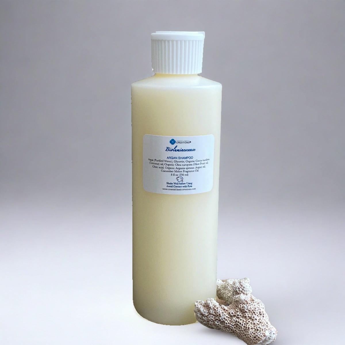 Bioluminescence Argan Facial Wash: An 8 oz  bottle with a white flip cap containing a fragrance-free, plant-based cleanser. The label showcases its natural ingredients, promising a gentle yet effective cleansing experience