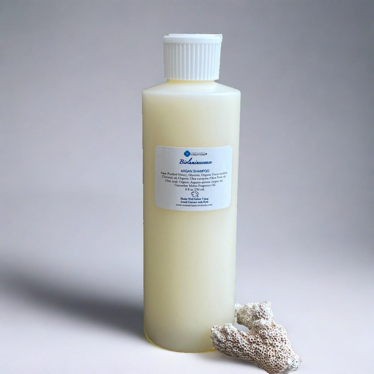 An 8-ounce bottle of Bioluminescence Argan Oil Shampoo with a white flip cap