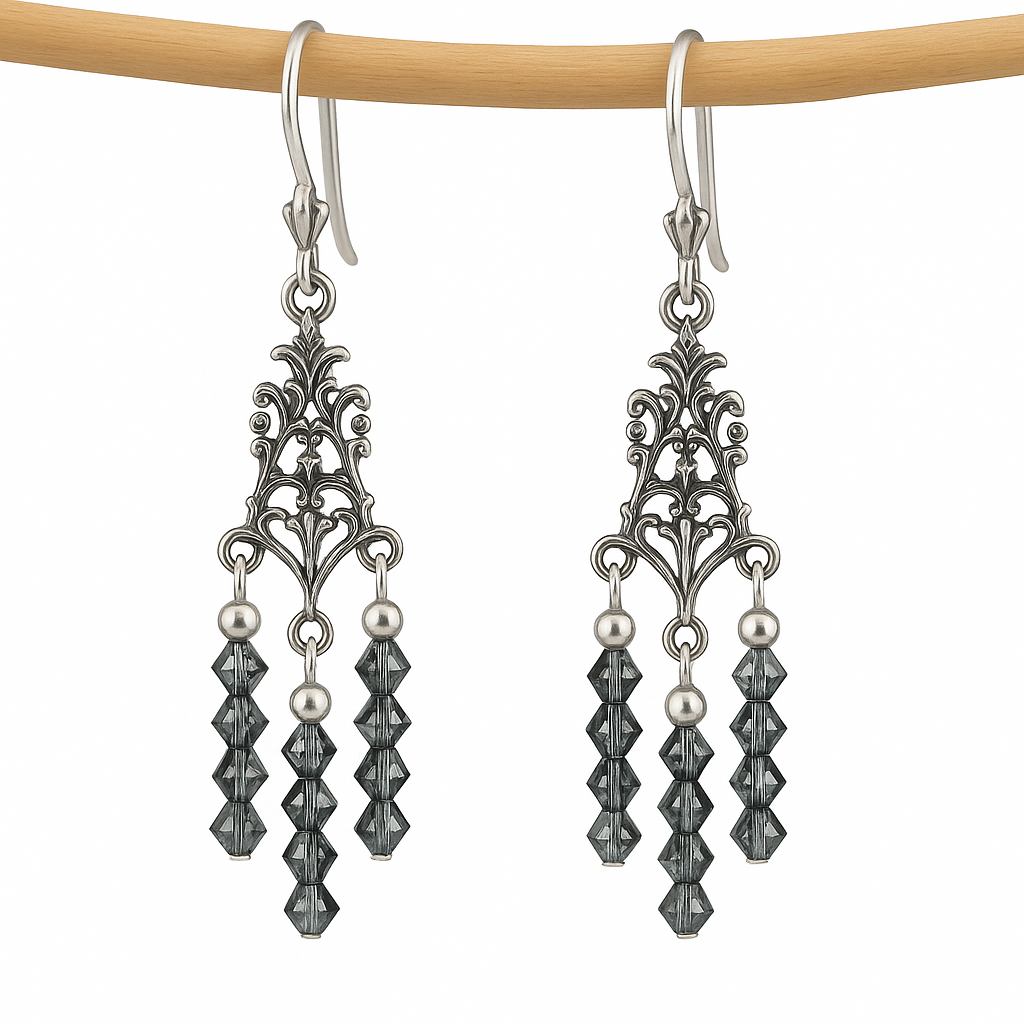 Sterling silver chandelier earrings with filigree tops and black diamond crystal beads on a white background