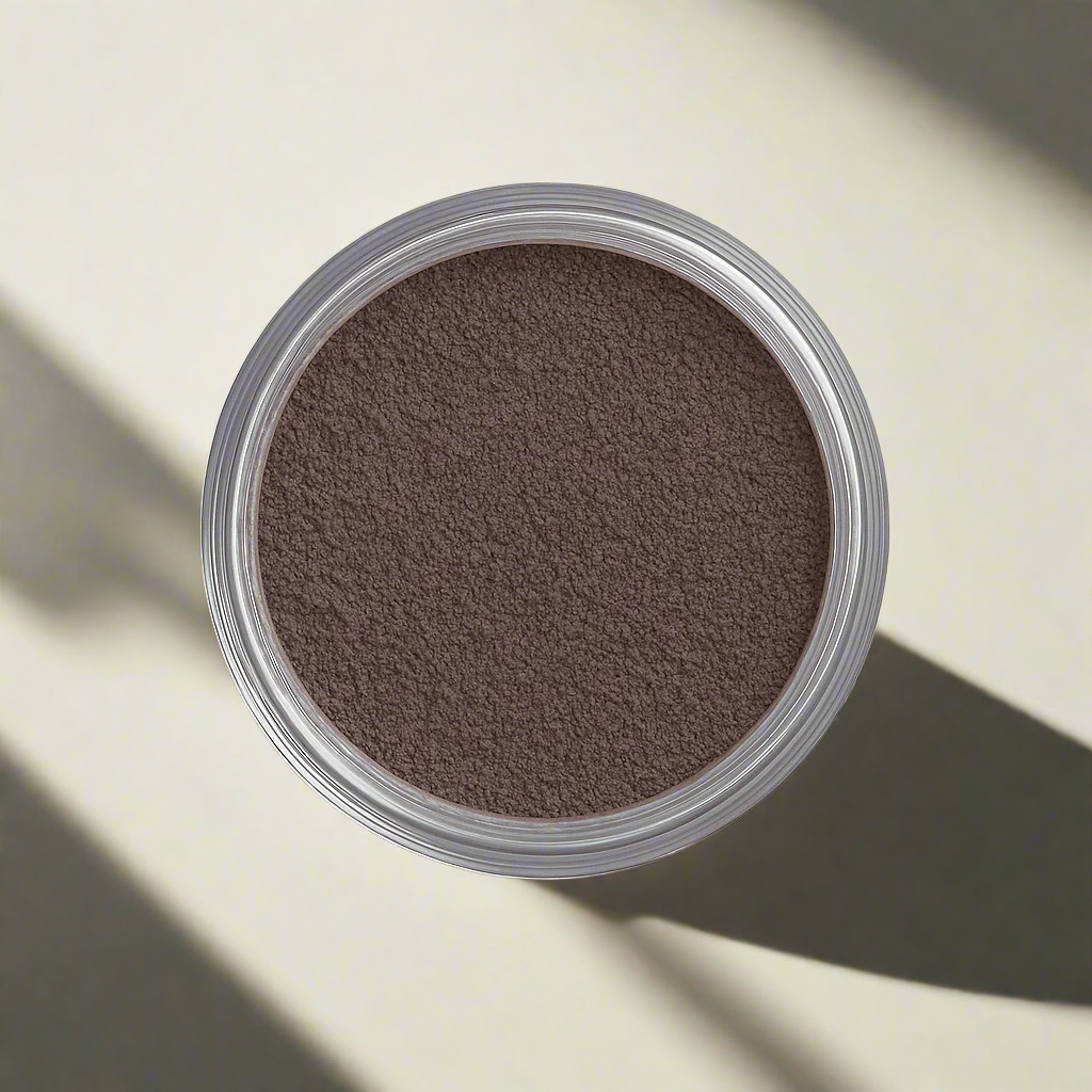 An open container of loose matte eyeshadow in chocolate plum. The powder has a soft, finely milled texture.