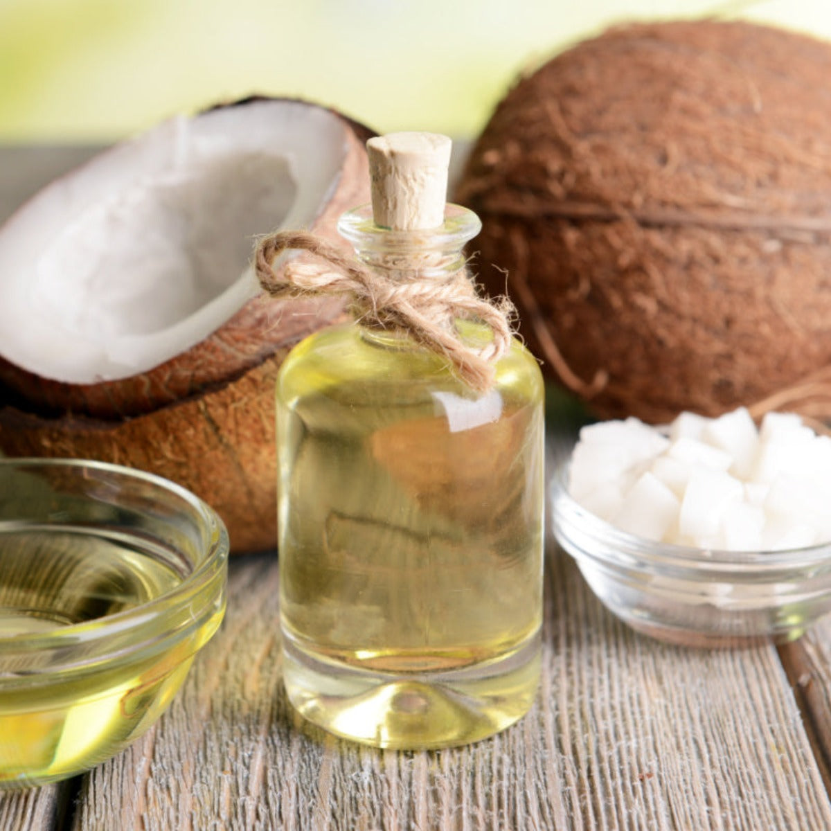 Bottle of coconut oil amidst sliced and whole coconuts, symbolizing a key ingredient in shea butter soap, capturing natural essence