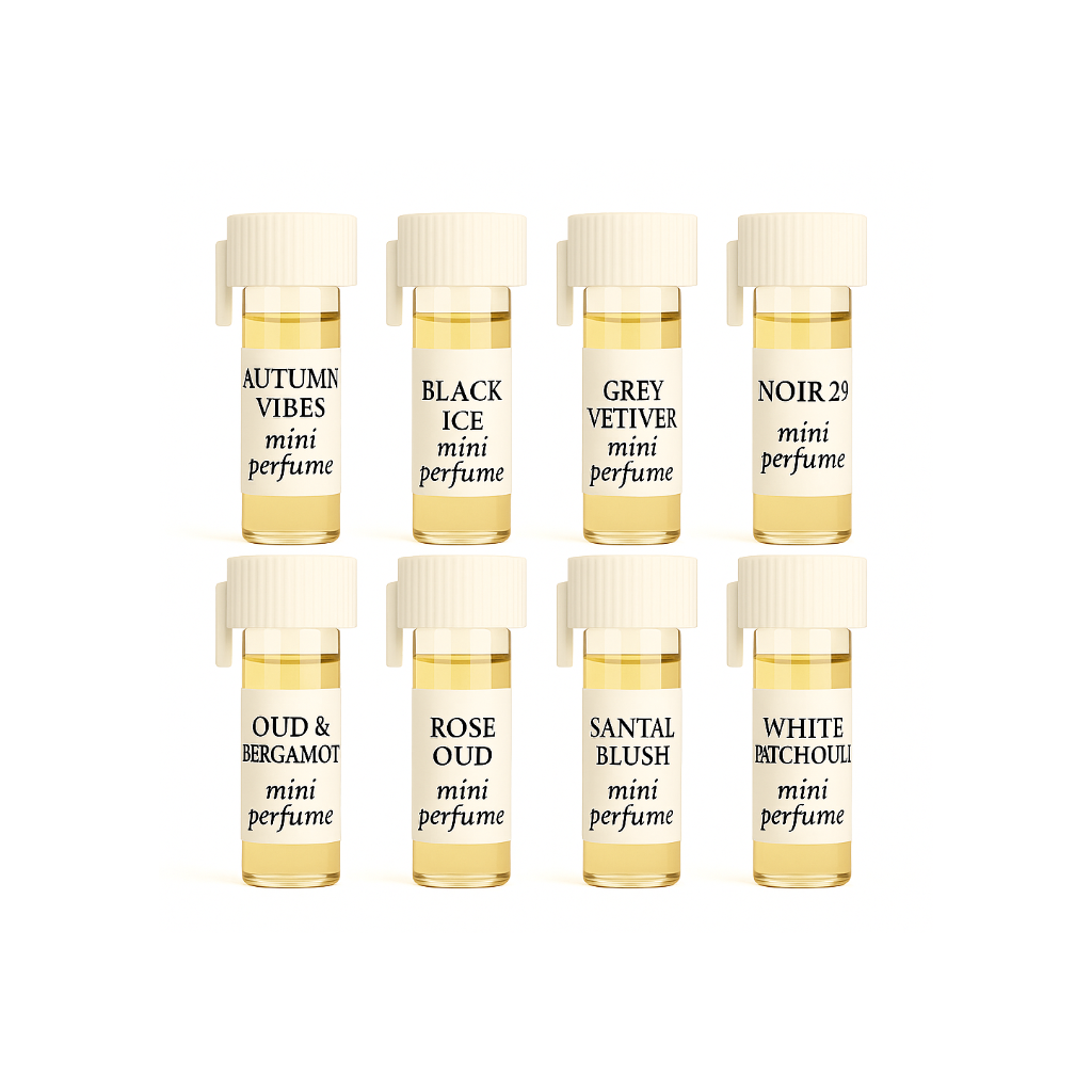 Designer Woody Mini Perfume Set featuring eight 1/6-dram vials of Autumn Vibes, Black Ice, Grey Vetiver, Noir 29, Oud & Bergamot, Rose Oud, Santal Blush, and White Patchouli arranged in two rows.