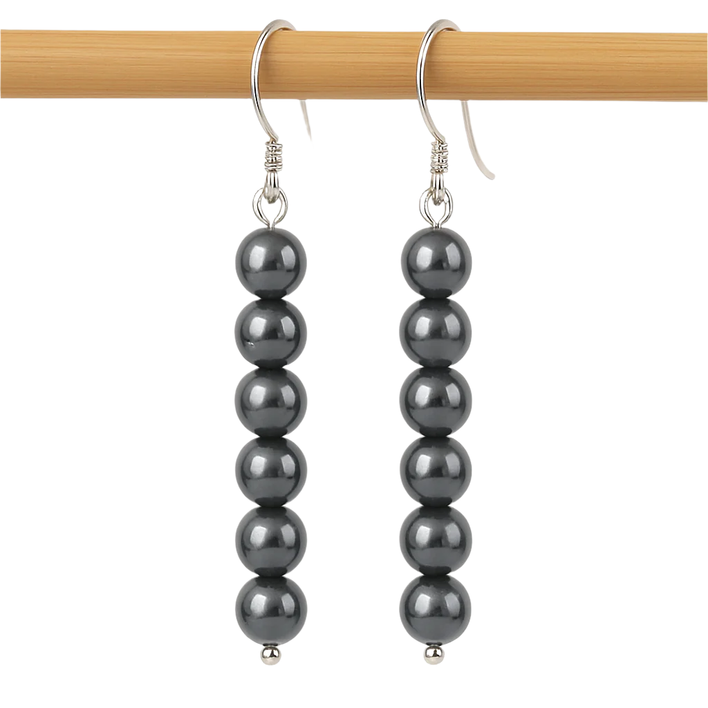 Dangle earrings with six round hematite stone beads on silver hooks, shown on a smooth wooden dowel