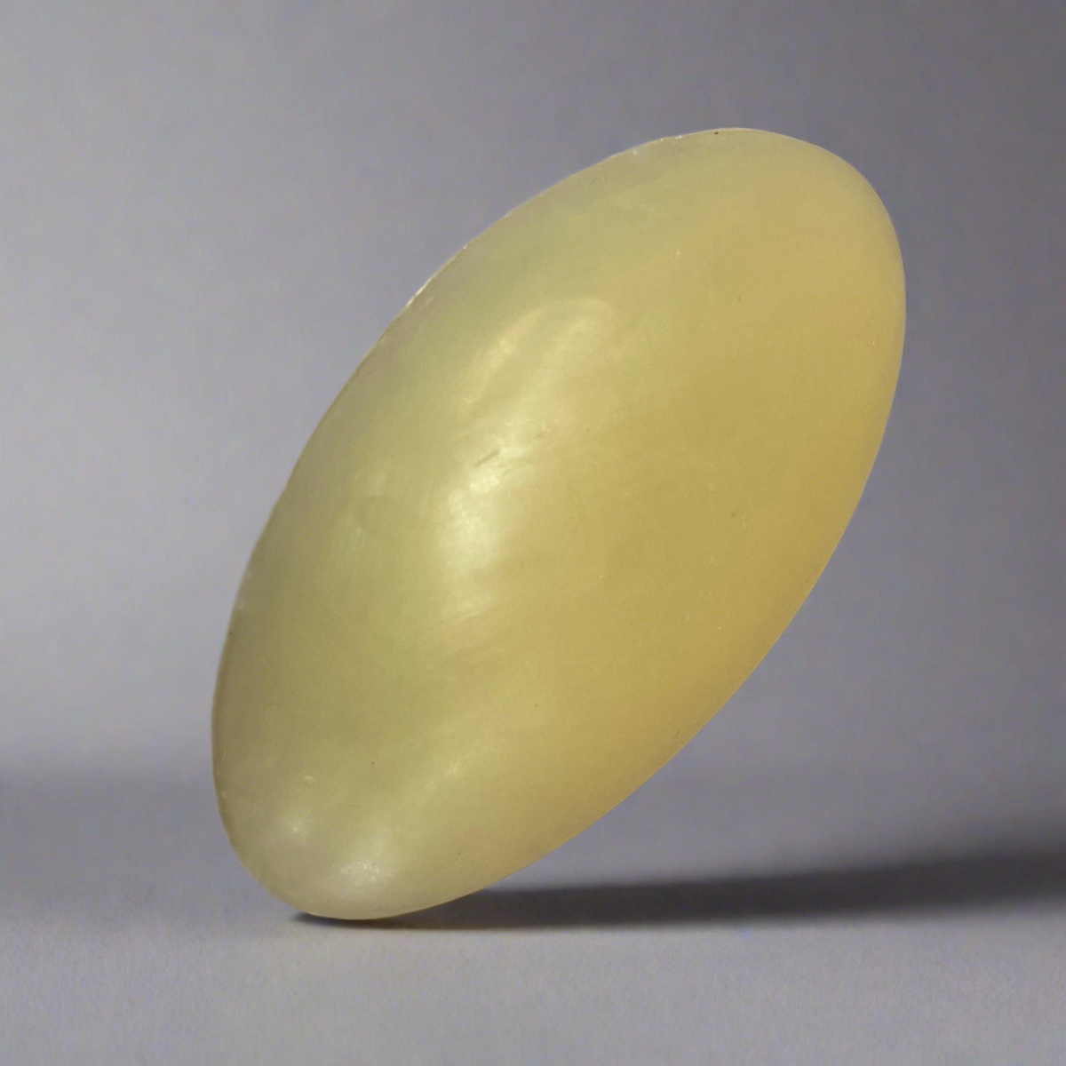 A Bioluminescence Hemp & Argan Oil Facial Bar in a contour shape, designed to fit comfortably in the hand