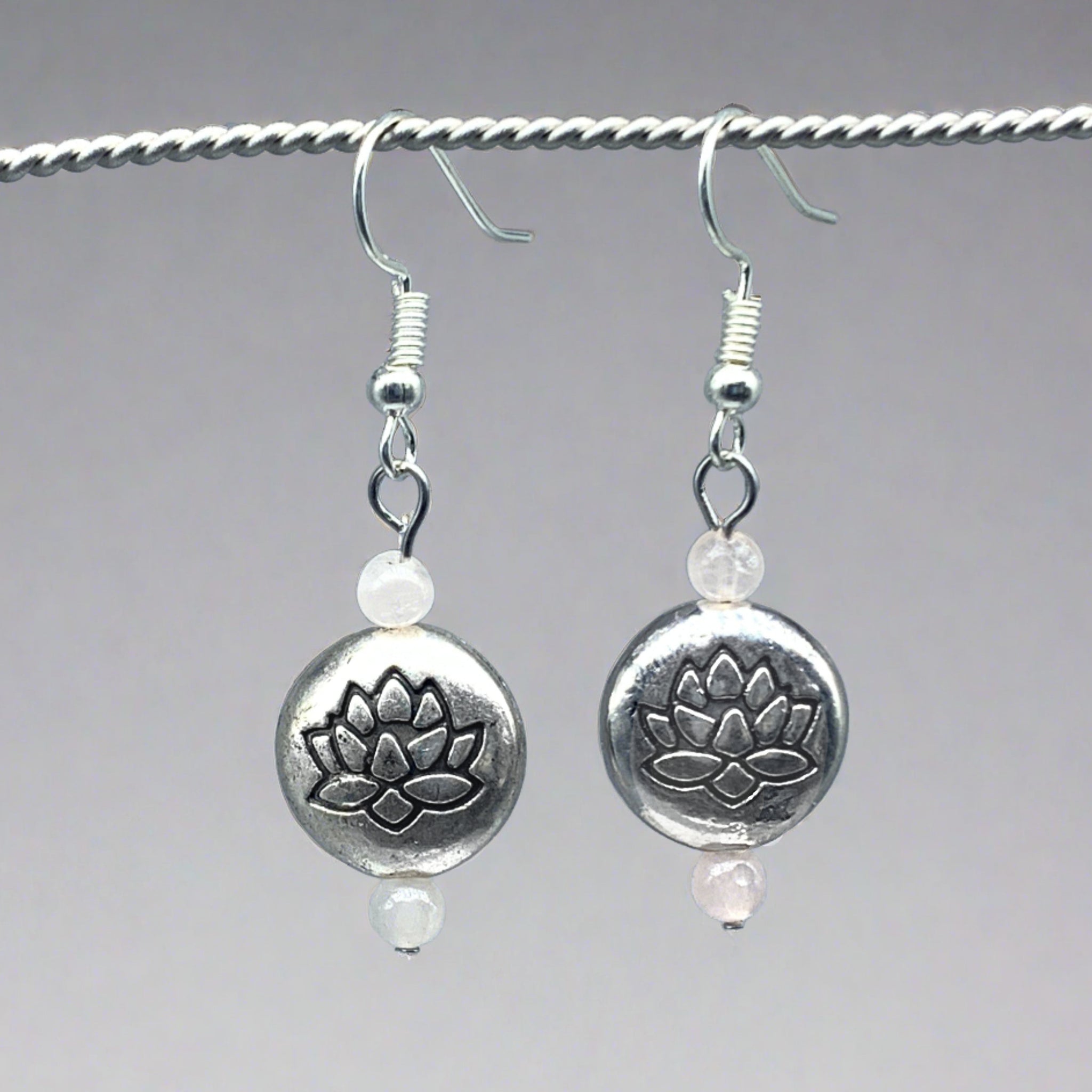 Lotus flower earrings for mindfulness on gray and yellow rock background