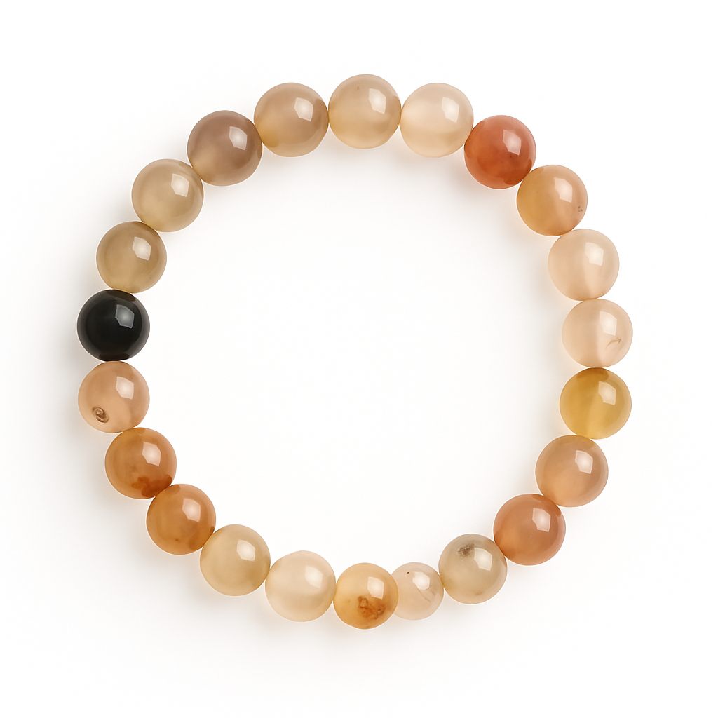 A stretch bracelet featuring polished 8mm dendritic agate beads from Madagascar, arranged in a circle on a pure white background. The beads range in warm, translucent tones of honey, amber, beige, and soft caramel, with occasional cloudy or dendritic inclusions. A single glossy black bead stands out among the earth tones, adding a grounding accent to the bracelet's overall look
