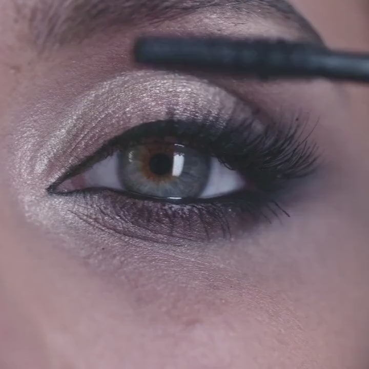Close-up of a woman applying Whispering Seas Super Lash Mascara, defining her lashes with a smooth, lengthening finish.