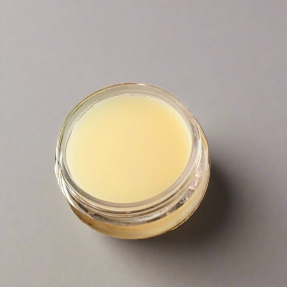 Small jar of Bioluminescence Argan Oil Lip Balm, a natural botanical solution for dry lips