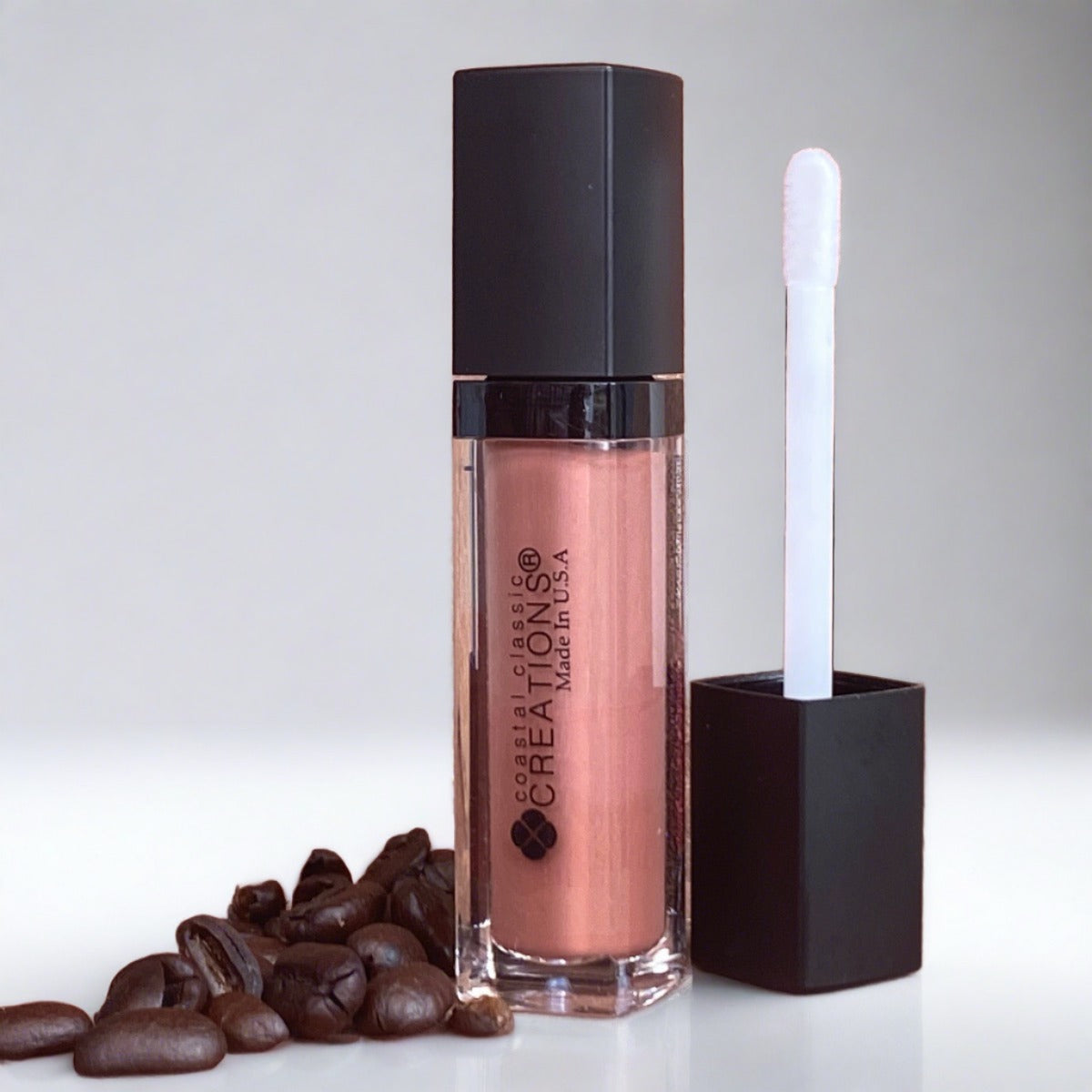 Pink Mousse 2-in-1 organic hemp lip gloss & conditioner representing Pink Mousse with coffee beans on rock background