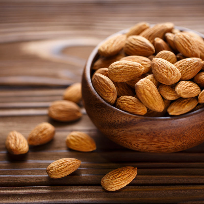 Wooden bowl of almonds representing product scent 