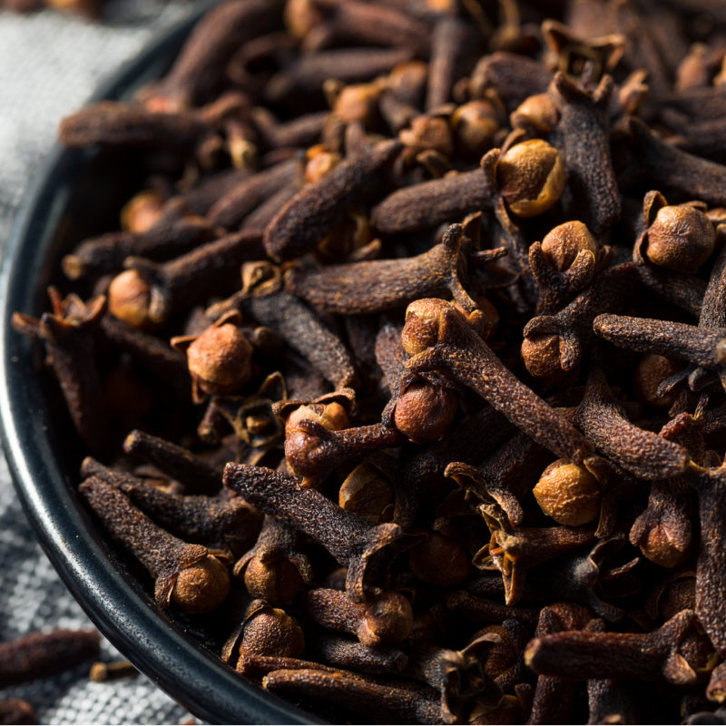 Bowl of dried cloves representing warm spice bay rum perfume ingredient 