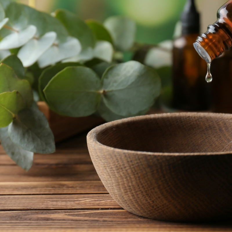 Eucalyptus oil being poured into wooden bowl representing product ingredient