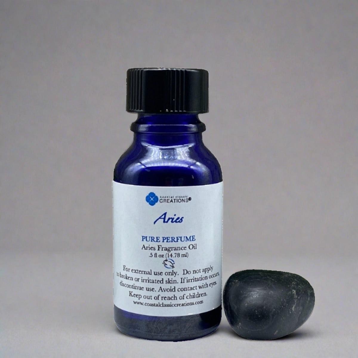Half-ounce blue bottle of Aries Perfume with a black cap, labeled with the product name and ingredients, featuring a sleek, cylindrical shape