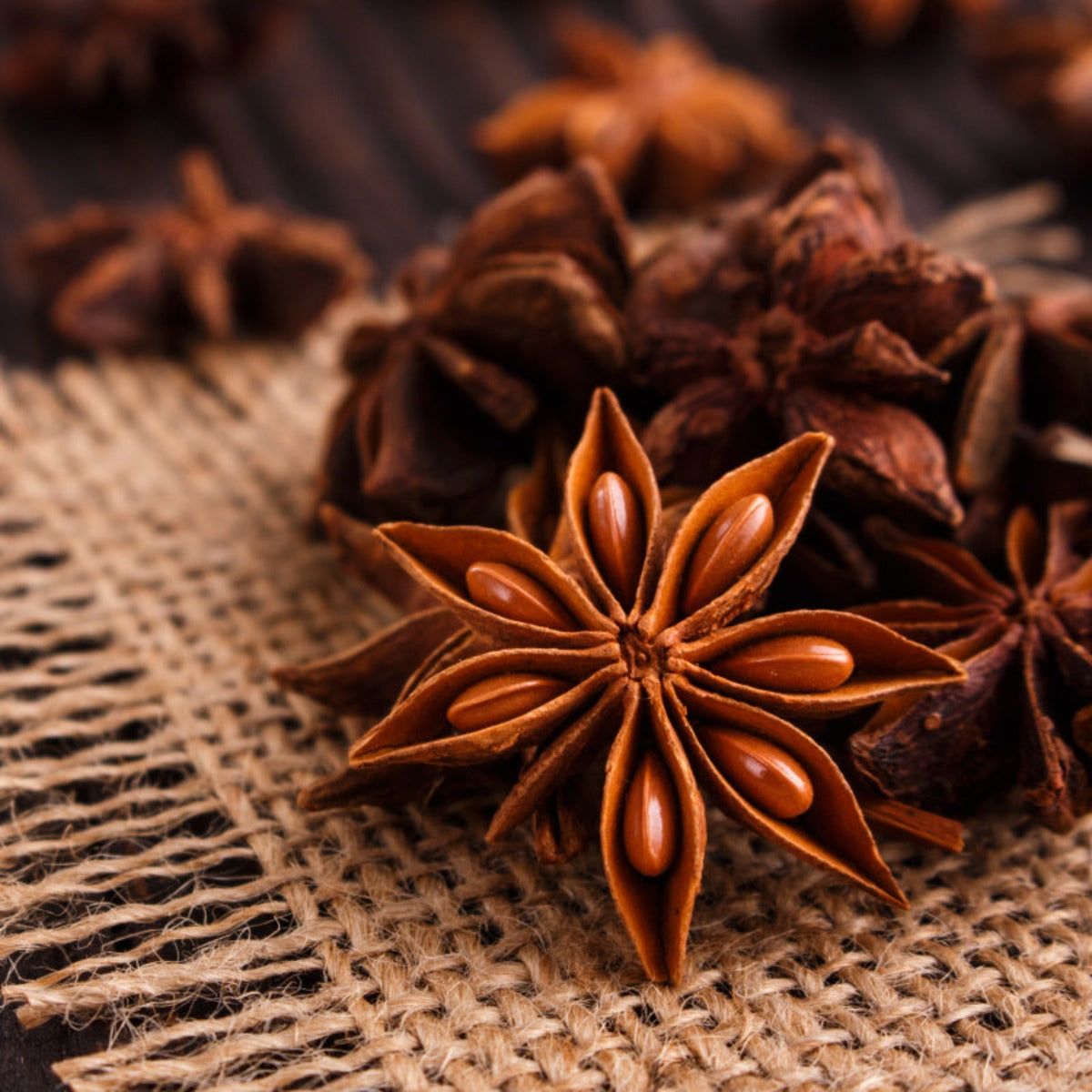 Group of star anise arranged on a hemp mat, symbolizing the aromatic essence found in Açaí Flower Perfume